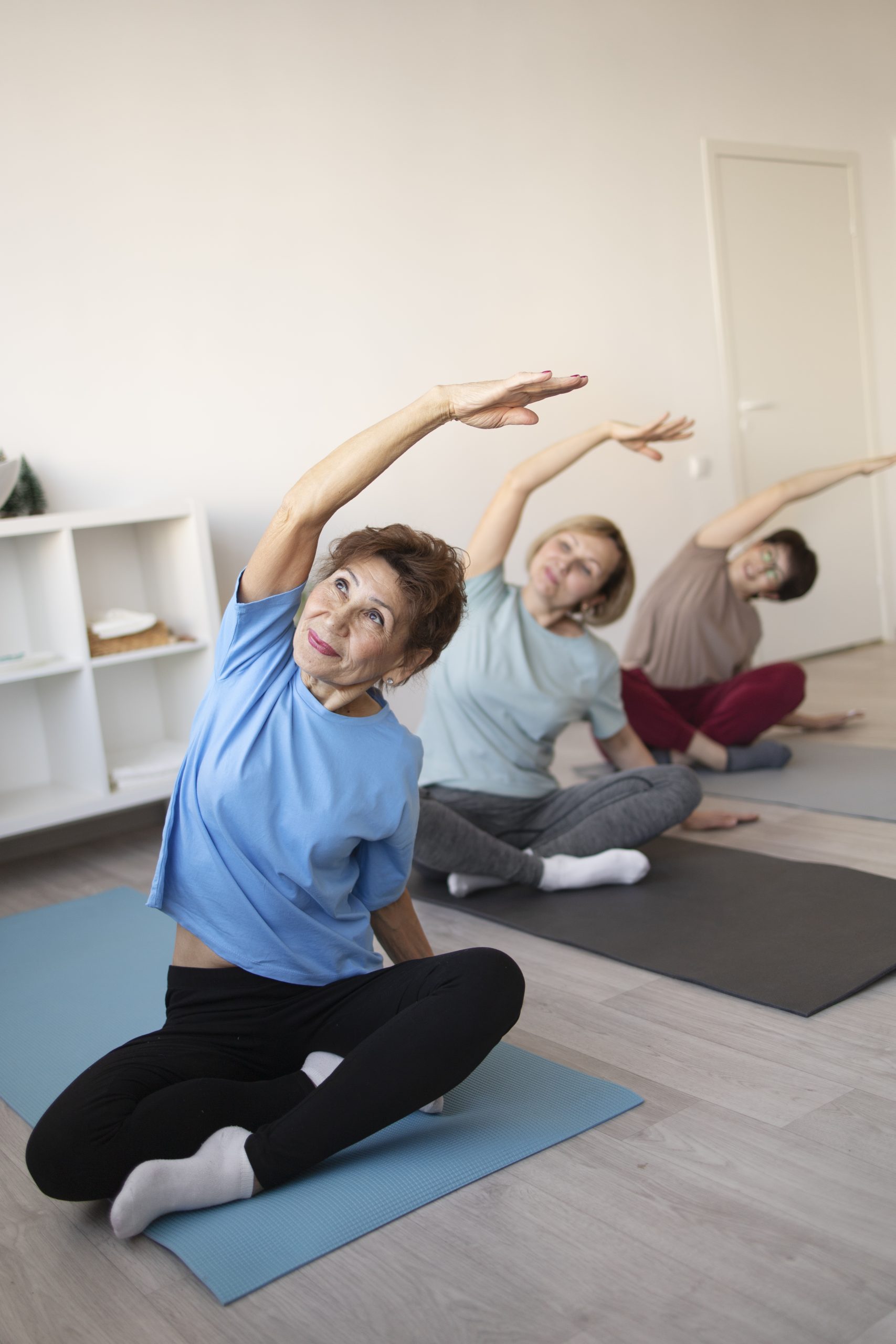 senior-women-doing-yoga-fitness-together-home